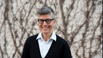 Forskaren Matilda Wurm står framför en tegelvägg med slingrande växtlighet. Hen ler mot kameran.