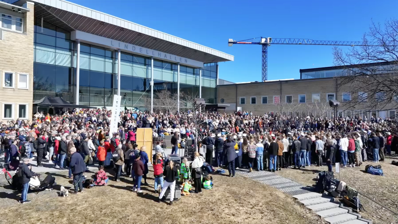 En stor grupp människor som står och lyssnar på evenemanget valborg på campus