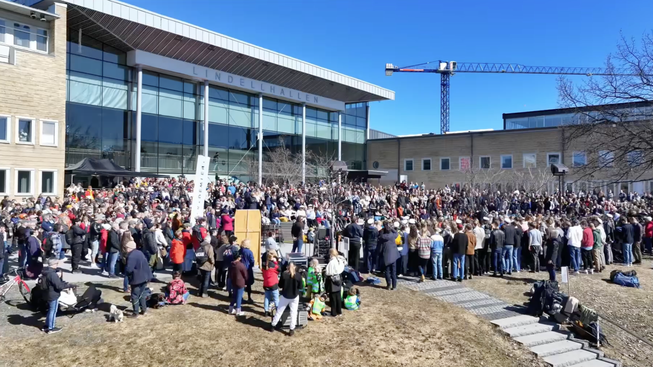 En stor grupp människor som står och lyssnar på evenemanget valborg på campus