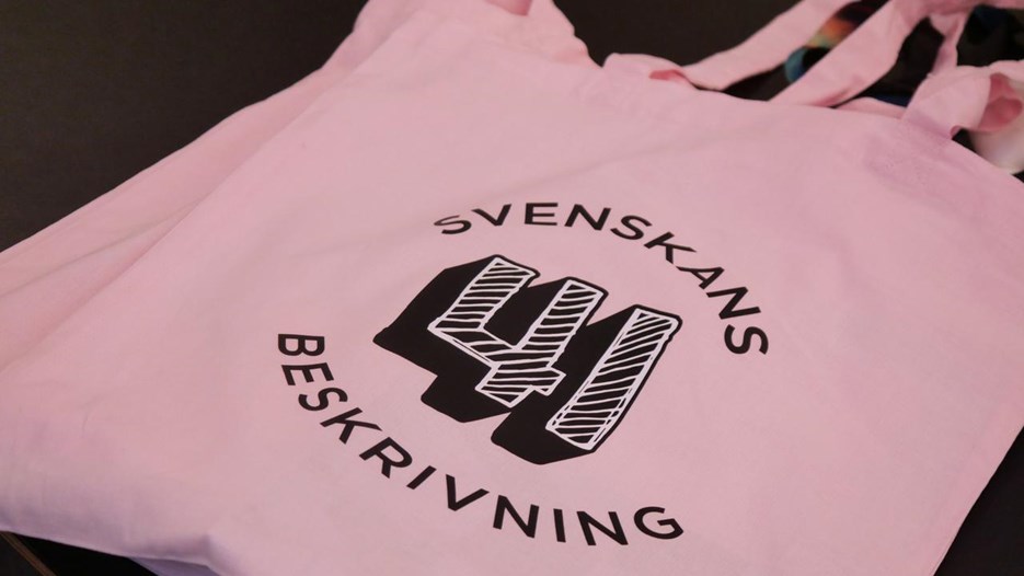 En rosa tygkasse som ligger på ett bord.