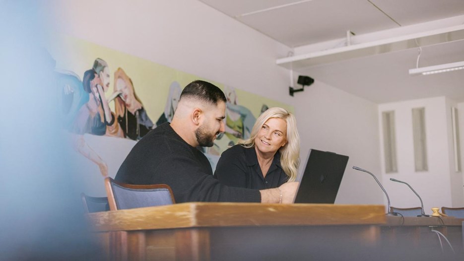 En lärare och en student sitter vid en dator