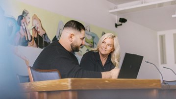 En lärare och student samtalar vid en dator