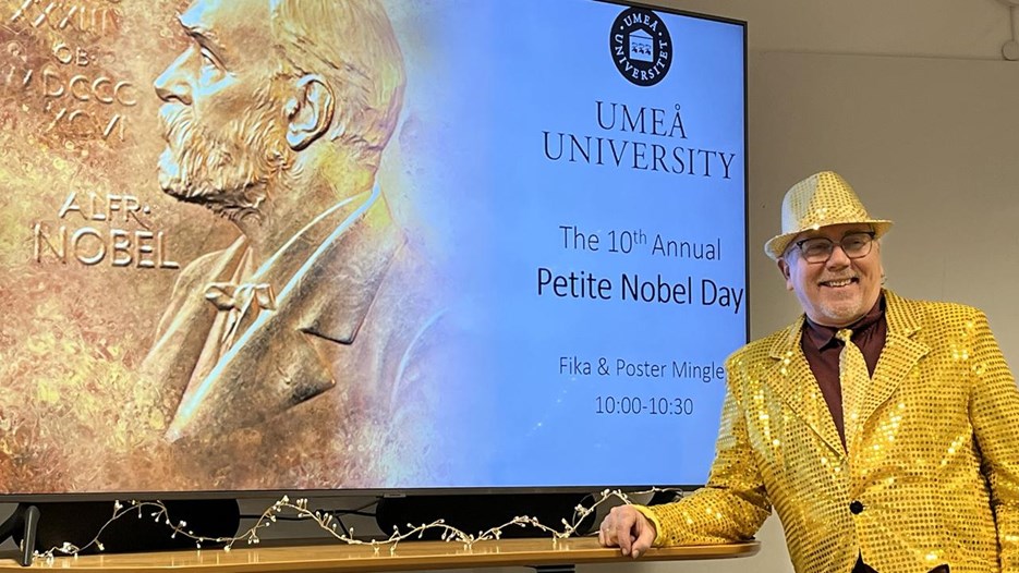 A man standing in front of a large screen.