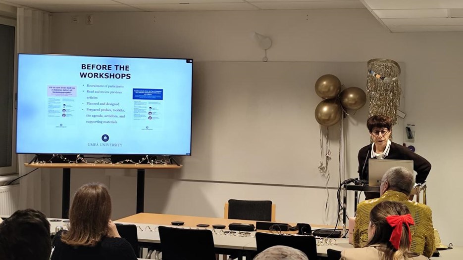 A group of people sitting in front of a projection screen.