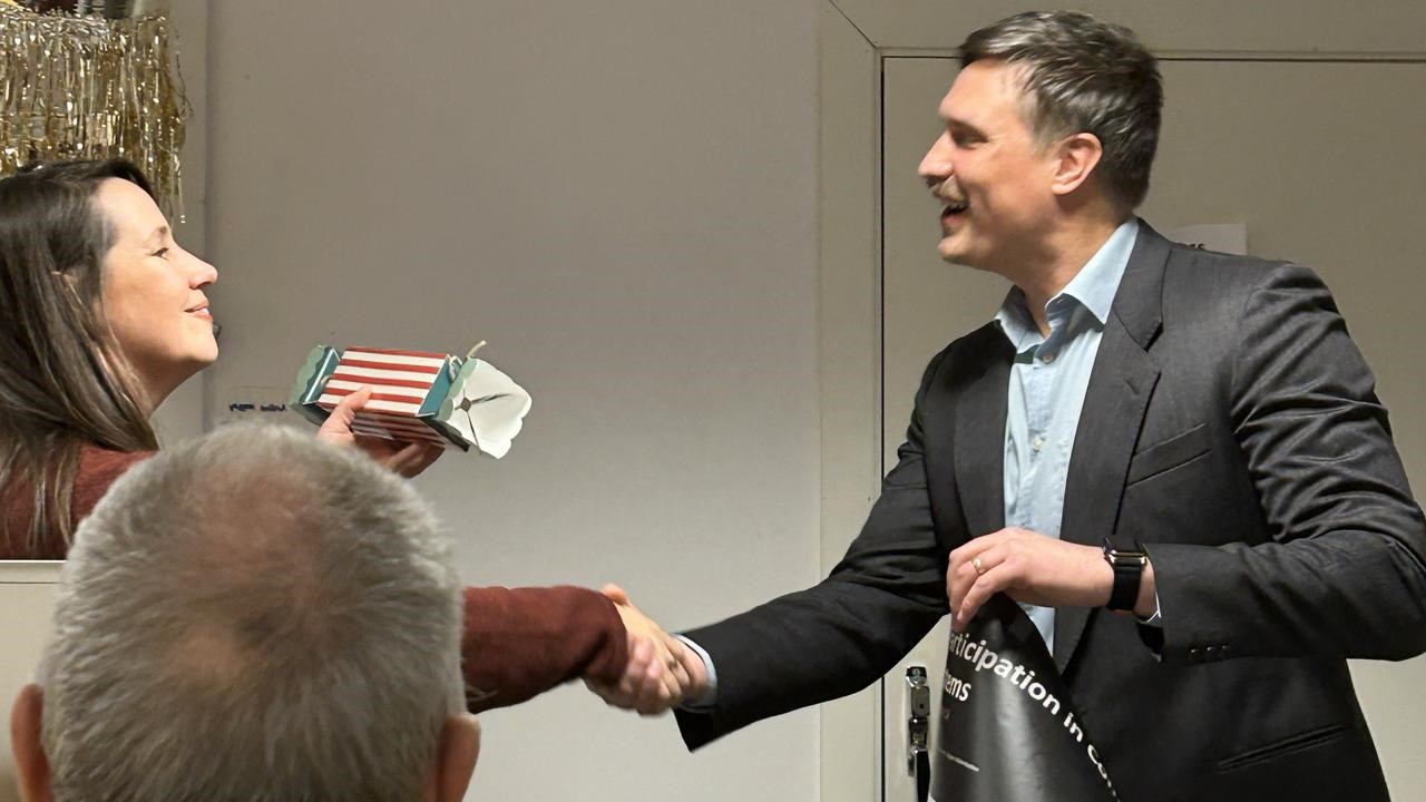 A man in a suit shaking hands with a woman