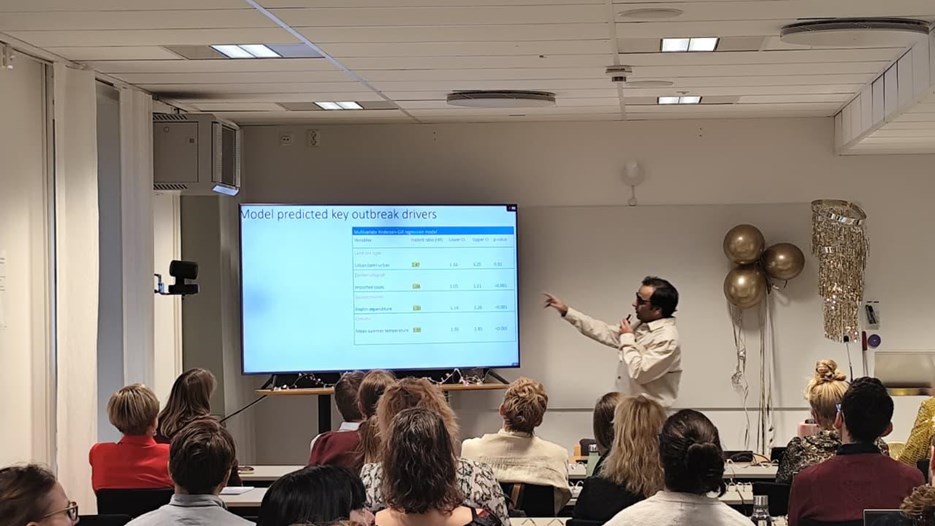 A group of people sitting in front of a projector screen.