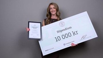 Olivia Lundin som håller en stor check och ett diplom i händerna.