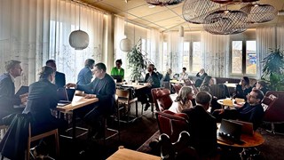 grupp av människor diskuterar vid olika bord