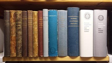 Flera upplagor av SAOL står på en hylla