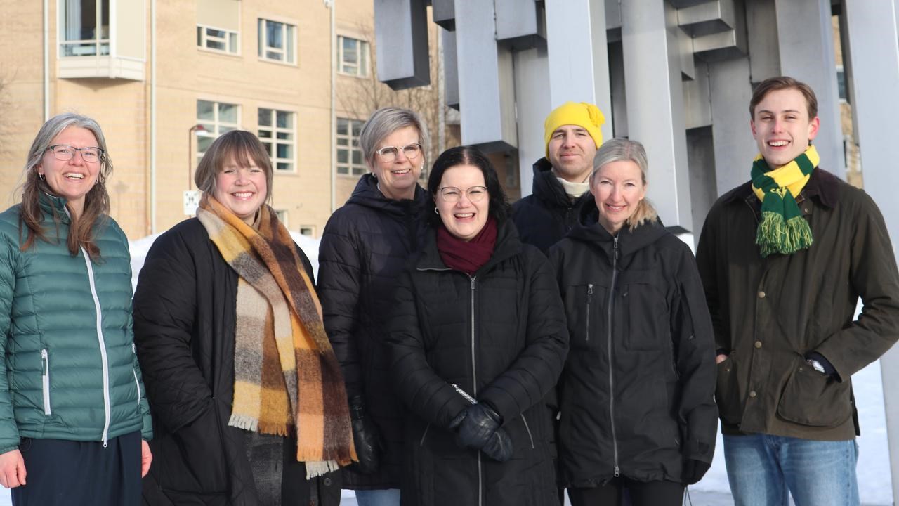 A group of people standing next to each other in front of the art object, Norra skenet,  Umeå Campus