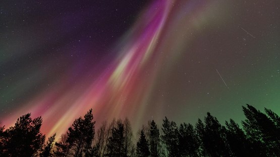 The aurora borealis is visible in the night sky.