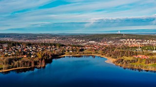 An overview of a rural society surrounded by a blue lake and a blue sky.
