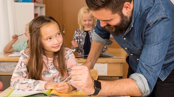 A teacher is helping a student in the classroom.