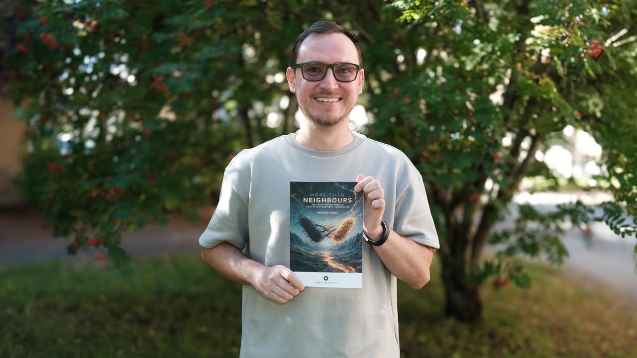 Dmytro holding his thesis