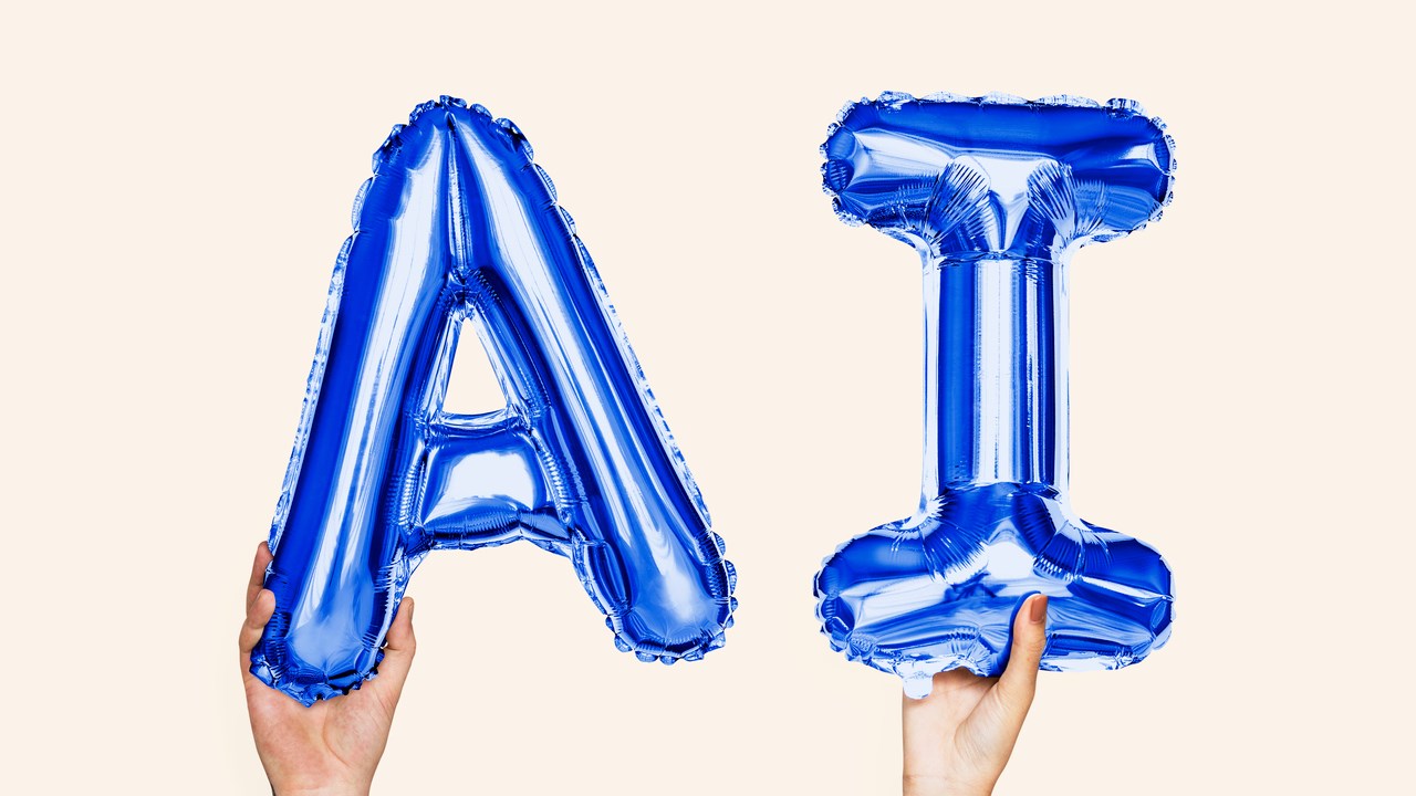 Två händer håller upp blå bokstavsballonger med bokstäverna A och I. För at illustrera artificiell intelligens.