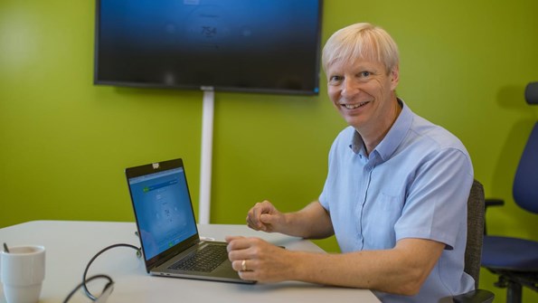 Kary Främling, professor i datavetenskap, sitter framför skärmar i ett grönt arbetsrum