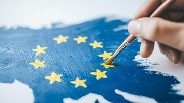 En person målar en EU-flagga.