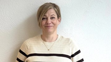 kvinna ler framför en vägg