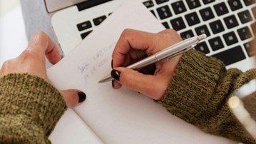 Hands writing on paper
