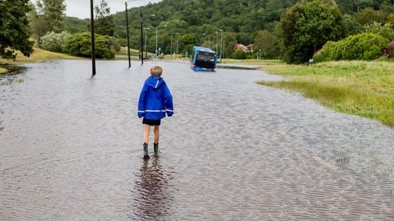 Pojke går på översvämmad gata