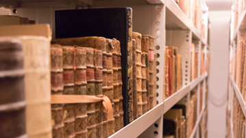 Arkivsamlingar i bokhyllor nere i magasinet i UB