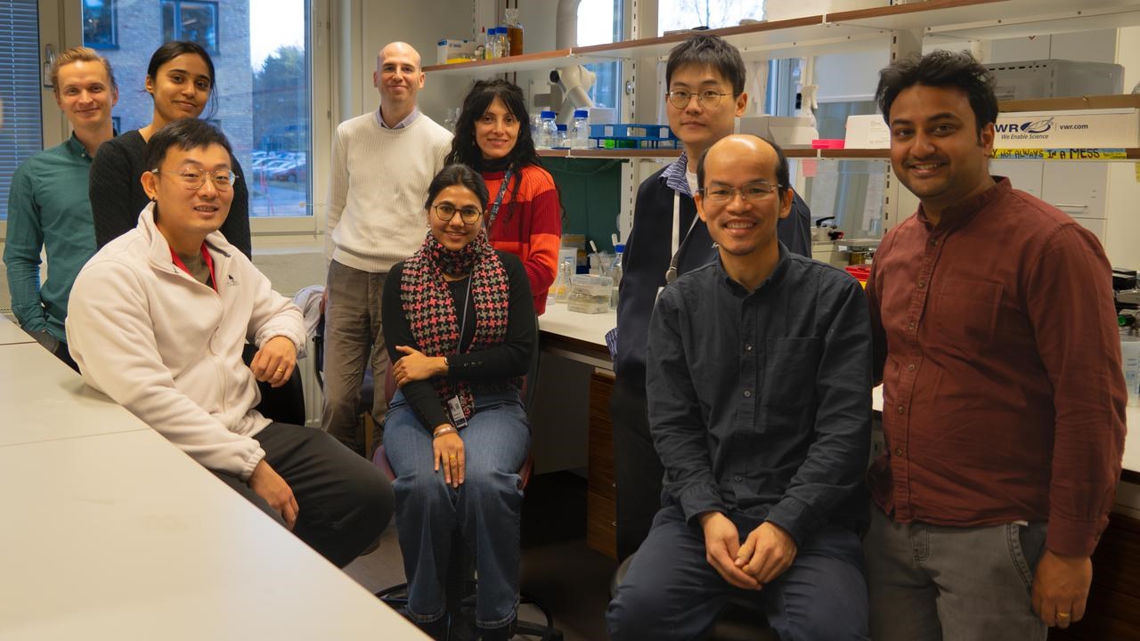 Gruppbild på nio personer i labbmiljö.