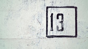 Talet tretton är skrivet på en betongvägg.