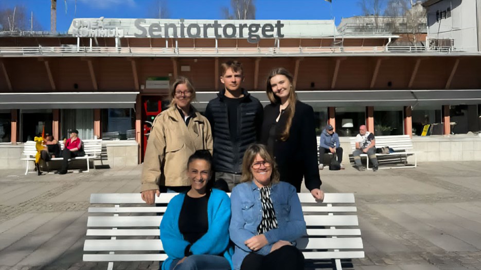 En grupp människor som sitter på en bänk.