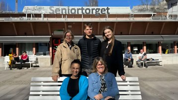 En grupp människor som sitter på en bänk.