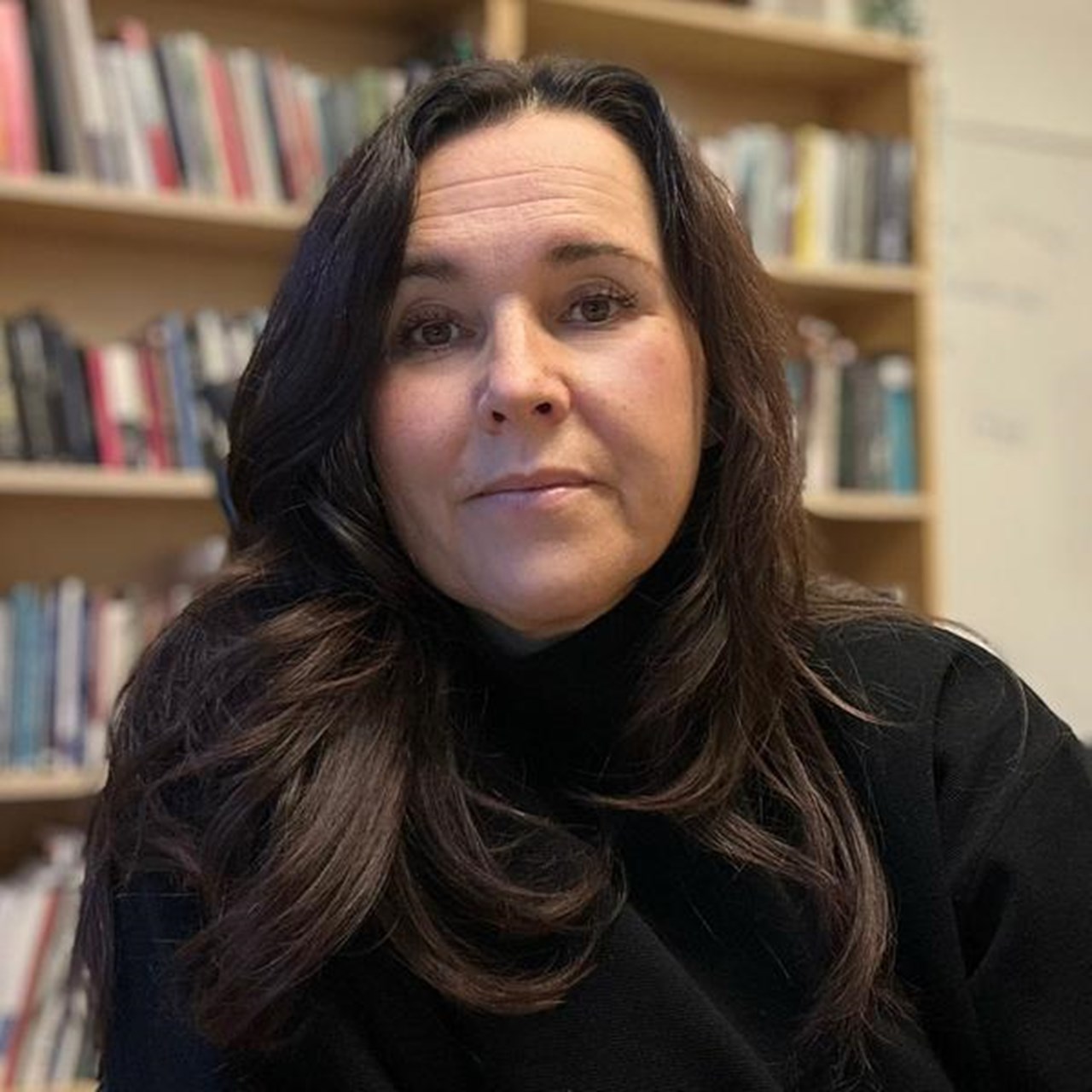 kvinna framf&ouml;r bokhylla