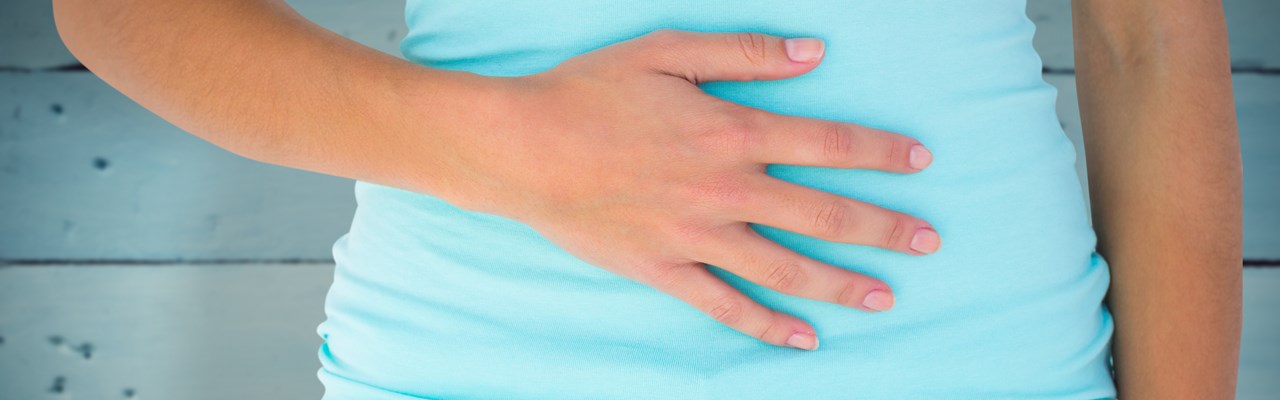 Detalj av kvinna som håller handen på magen.
