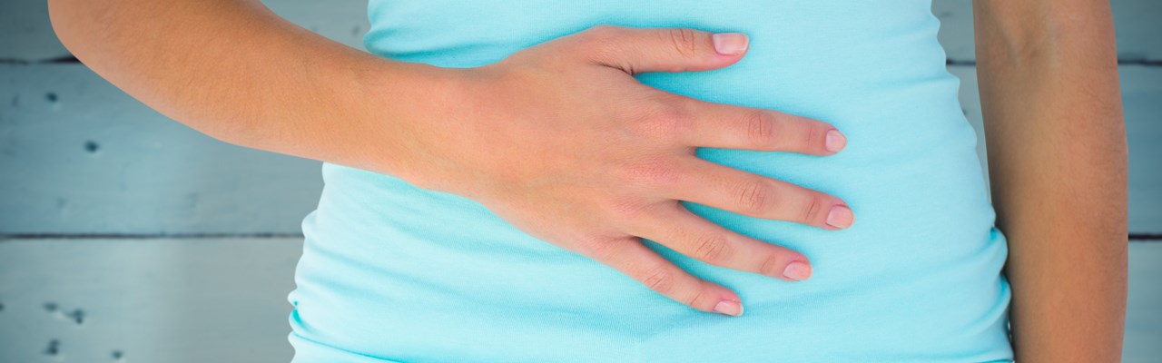 Detalj av kvinna som håller handen på magen.