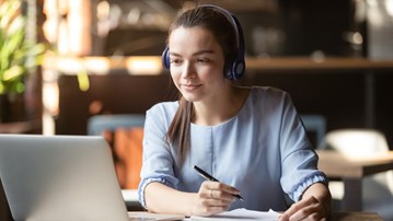 Kvinna som sitter i framför datorn i ett digitalt möte.