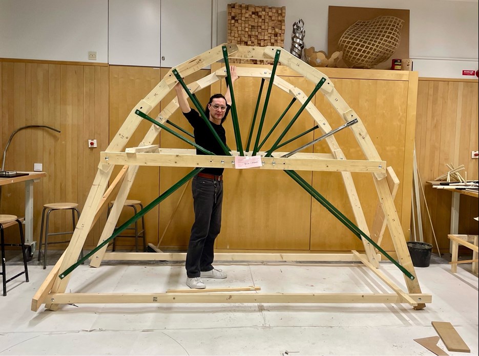 Julio Diarte stands in a wooden construction shaped like a valve.