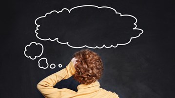 Person bakifrån vid svart tavla med en illustrerad tänkebubbla ovanför huvudet. För att illustrera tänka.