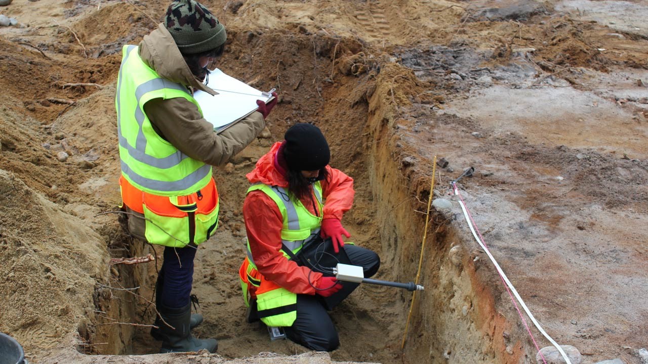 Two students of archaeology investigates an earli metal production site using magnetic suceptibility