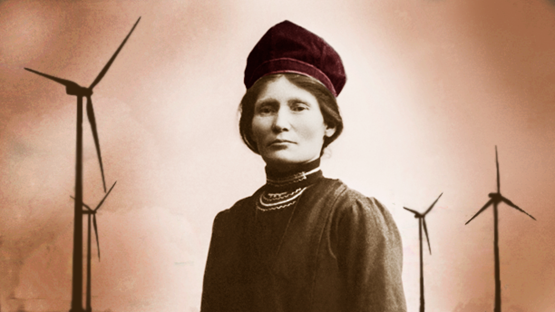 Elsa Laula stands in front of wind turbines.