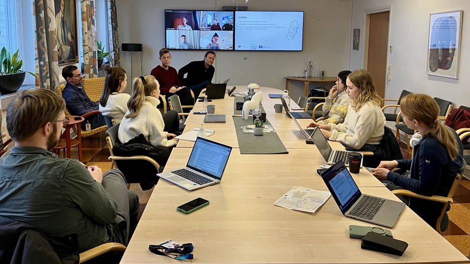 The Doctoral students at the Arctic Graduate School sit around a table and work.