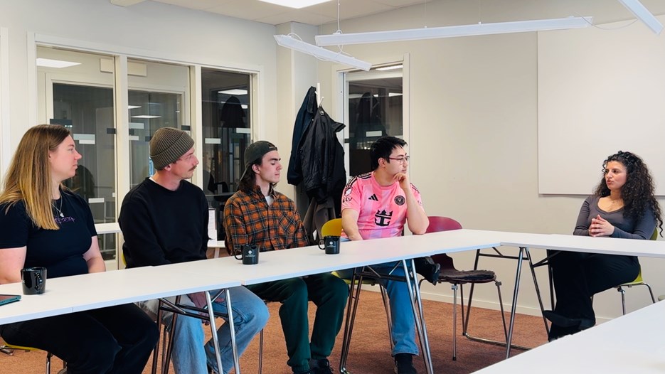 Foto på deltagare runt ett bord som pratar