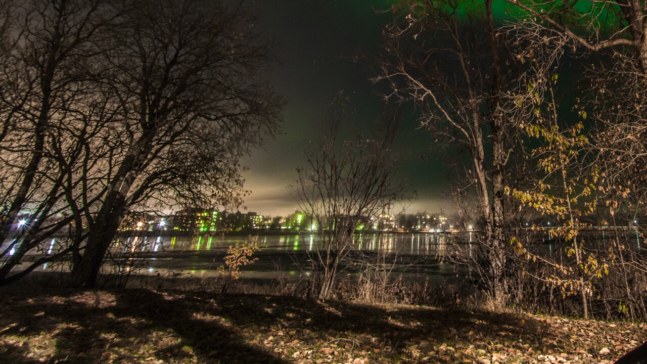 Person sitting outside watching the northern lights. 