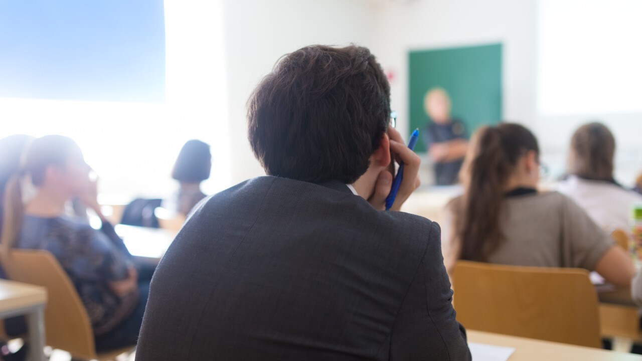 Ungdomar i klassrum lyssnar på lärare som undervisar.