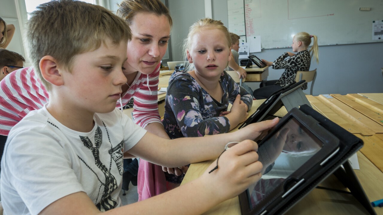 Barn i klassrum använder surfplatta.