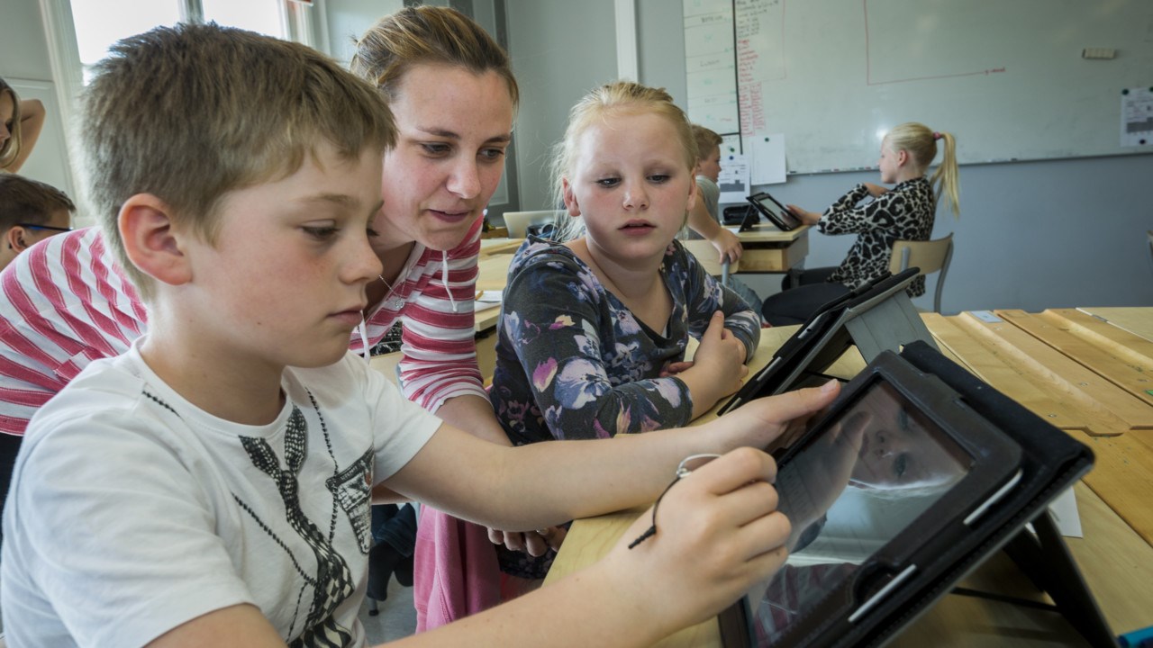 Barn i klassrum använder surfplatta.