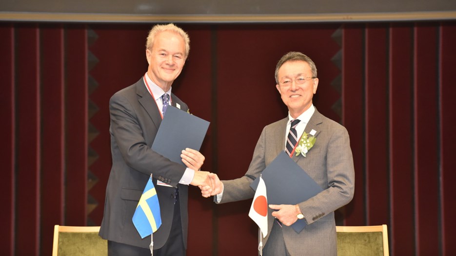 The Swedish Ambassador Magnus Robach and deputy minister Yoshio Yamawaki shake hands.