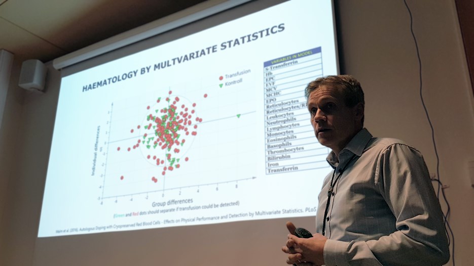 Christer Malm, Professor at Department of Community Medicine and Rehabilitation, in front of a powerpoint presentation of haematology data.