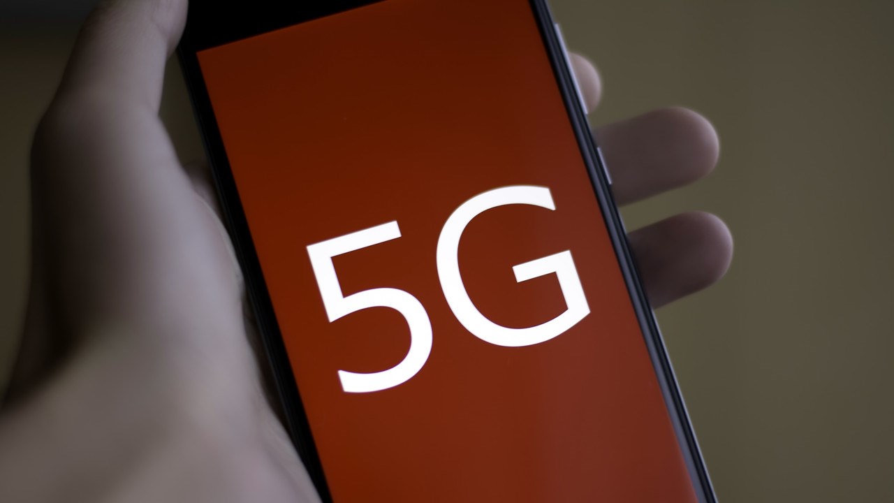 Hand som håller i mobiltelefon med ordet 5G på skärmen. Ska illustrera 5G-teknik.