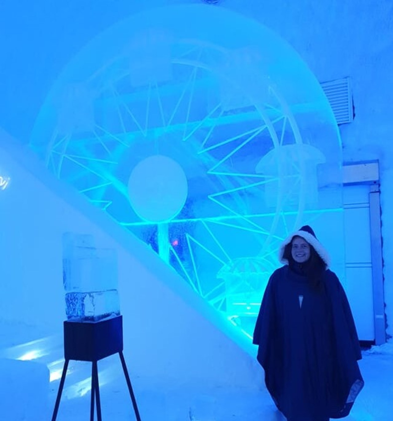 Moa Mattson, PhD student at the Department of Applied Physics and Electronics, Umeå University, is wearing a long dark poncho with a fur collar at an ice formation 'Ferris wheel' inside the ice hotel in Jukkasjärvi.