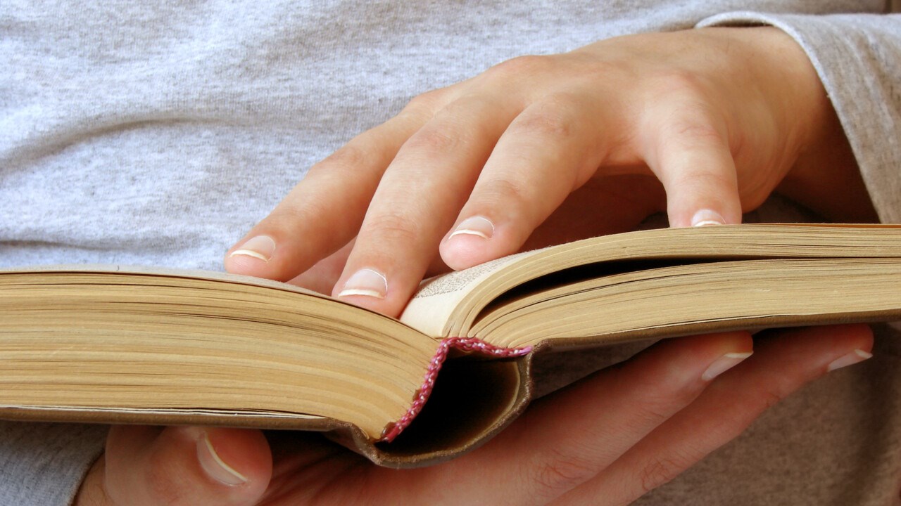 Hands that hold an open book.