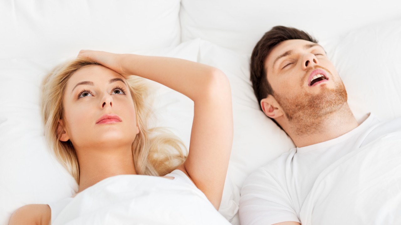 Snoring man beside sleapless woman