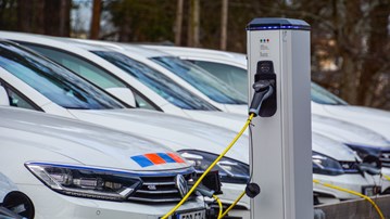 Elbil inkopplad till laddare på parkering